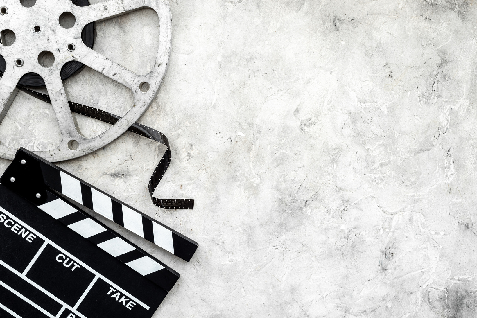 Cinema background with movie clapperboard and film reel